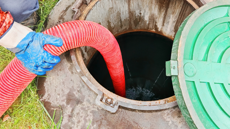 Septic tank service with hose being inserted into the tank for cleaning,Pipe in a drain hole